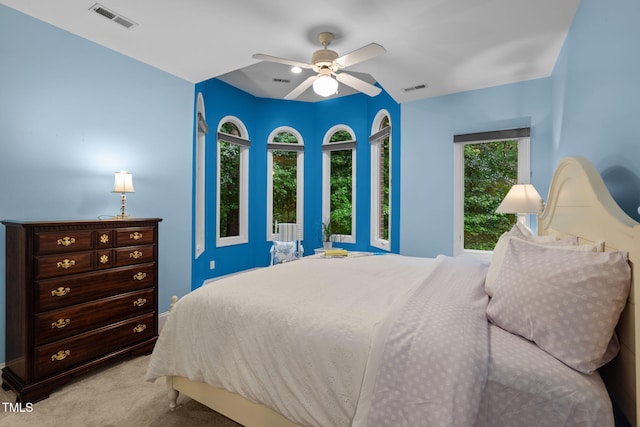 bedroom featuring light colored carpet, visible vents, and a ceiling fan