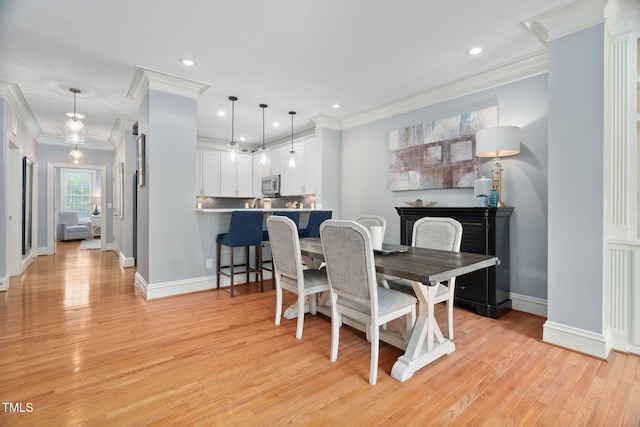 dining space with crown molding, recessed lighting, baseboards, and light wood-type flooring