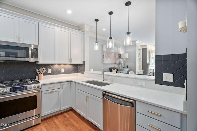 kitchen with light wood-style flooring, decorative backsplash, a sink, and stainless steel appliances