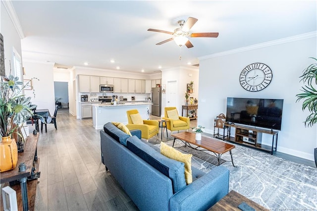 living area featuring baseboards, recessed lighting, a ceiling fan, crown molding, and light wood-style floors