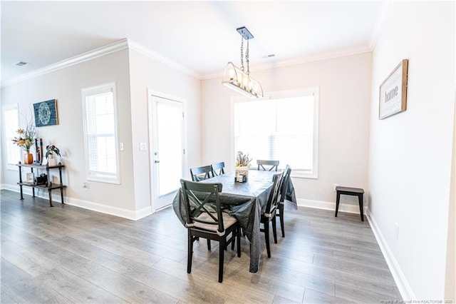 dining area with baseboards, crown molding, and wood finished floors