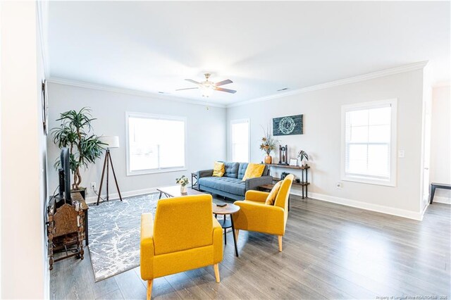 living area with ornamental molding, baseboards, a ceiling fan, and wood finished floors