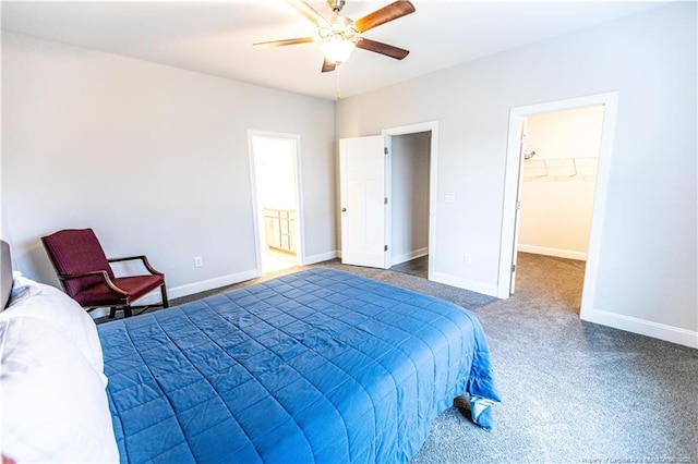 bedroom with a walk in closet, carpet, and baseboards