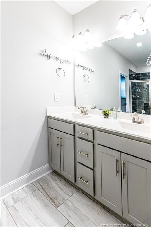 full bath featuring a shower stall, double vanity, and a sink