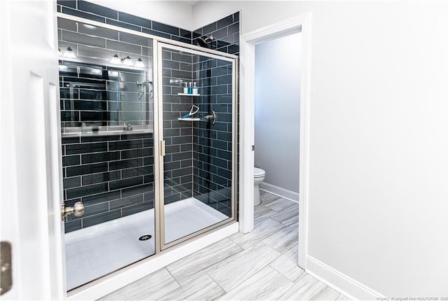 full bath featuring toilet, baseboards, and a stall shower