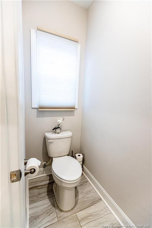 bathroom with baseboards and toilet