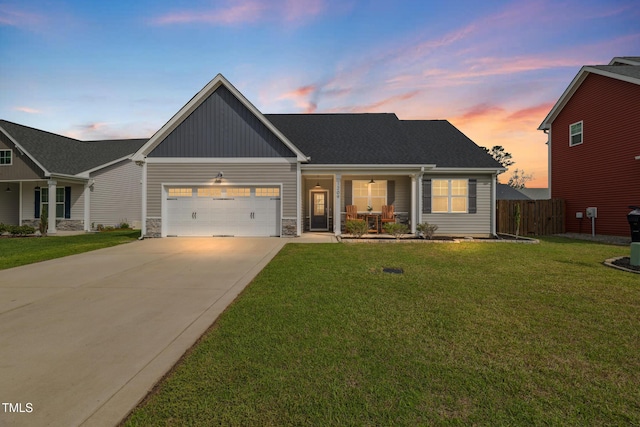 1209 Big Field Dr, Castle Hayne, NC 28429 - view of front of home featuring driveway, stone siding, a garage, a yard, and fence