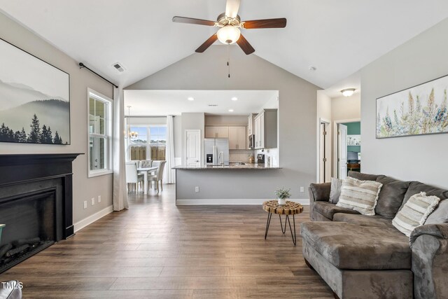 1209 Big Field Dr, Castle Hayne, NC 28429 - living room with visible vents, baseboards, dark wood-style floors, ceiling fan with notable chandelier, and a glass covered fireplace