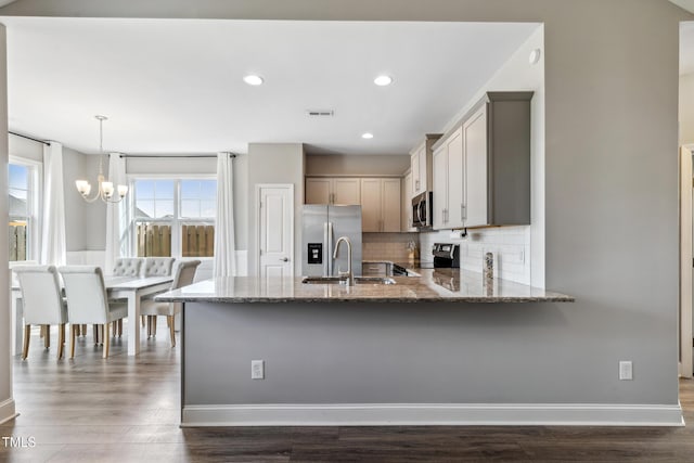 1209 Big Field Dr, Castle Hayne, NC 28429 - kitchen featuring stone countertops, a peninsula, visible vents, stainless steel appliances, and a sink