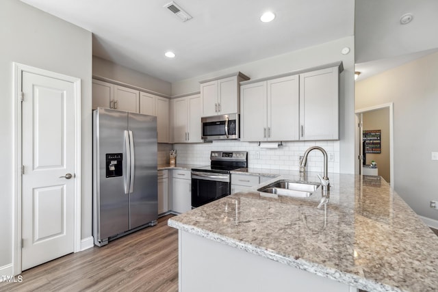 1209 Big Field Dr, Castle Hayne, NC 28429 - kitchen with backsplash, light stone countertops, visible vents, appliances with stainless steel finishes, and a sink