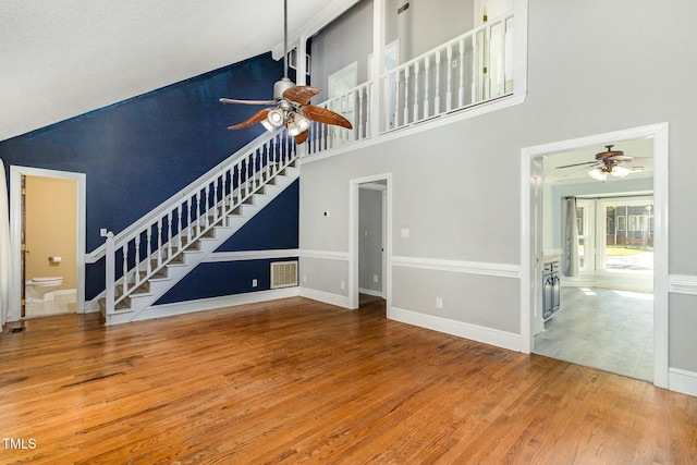 3109 E Folkestone Pl, Raleigh, NC 27604 - unfurnished living room featuring visible vents, a ceiling fan, wood finished floors, stairway, and high vaulted ceiling