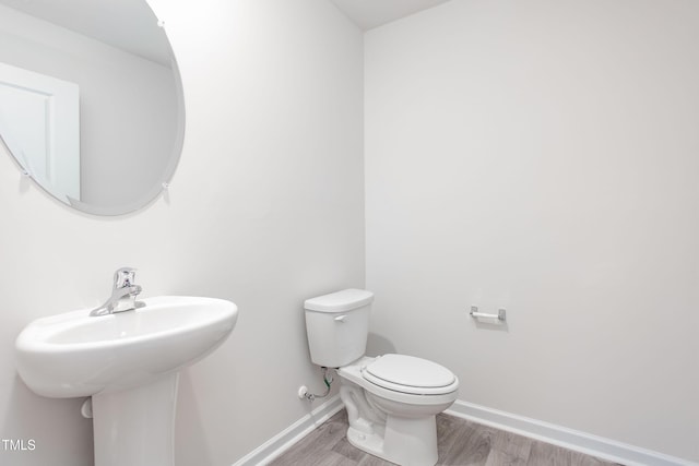2134 Monk Dr, Haw River, NC 27258 - half bath with toilet, baseboards, wood finished floors, and a sink