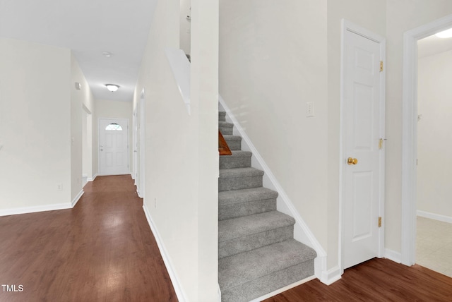 stairway featuring baseboards and wood finished floors