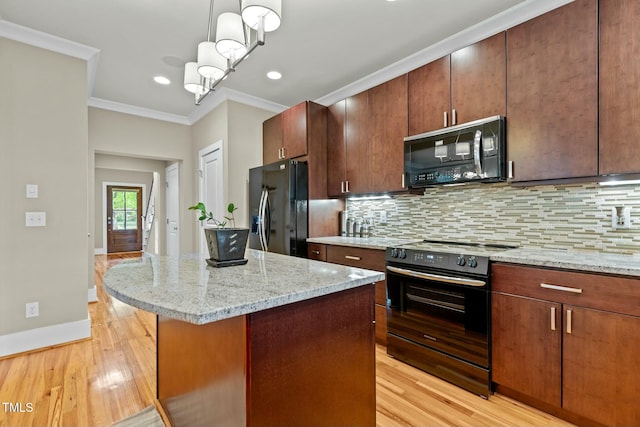 kitchen featuring crown molding, decorative backsplash, light wood-style flooring, and black appliances