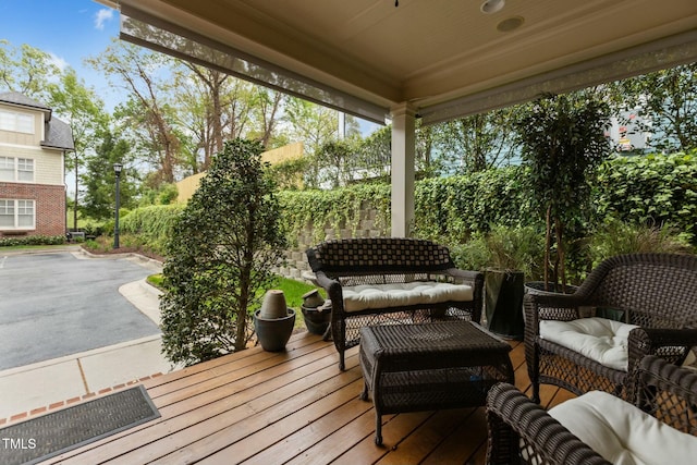 wooden terrace featuring a patio area, an outdoor living space, and fence