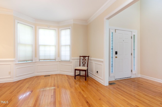 113 Beeley Ct, Cary, NC 27519 - entrance foyer featuring light wood-style flooring, ornamental molding, visible vents, and a wainscoted wall