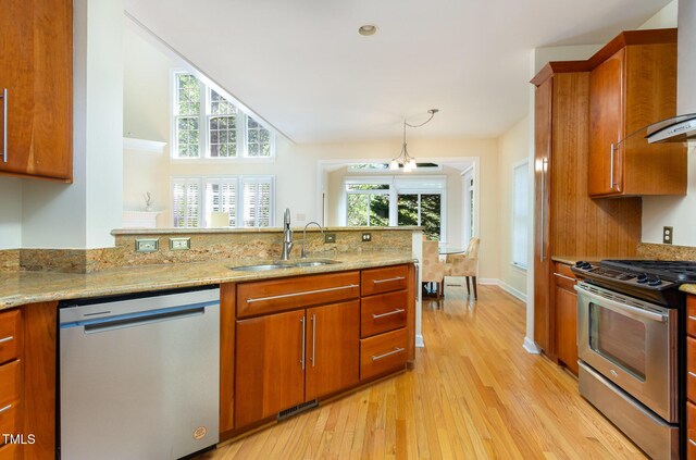 113 Beeley Ct, Cary, NC 27519 - kitchen with light wood-style floors, brown cabinets, a sink, and appliances with stainless steel finishes
