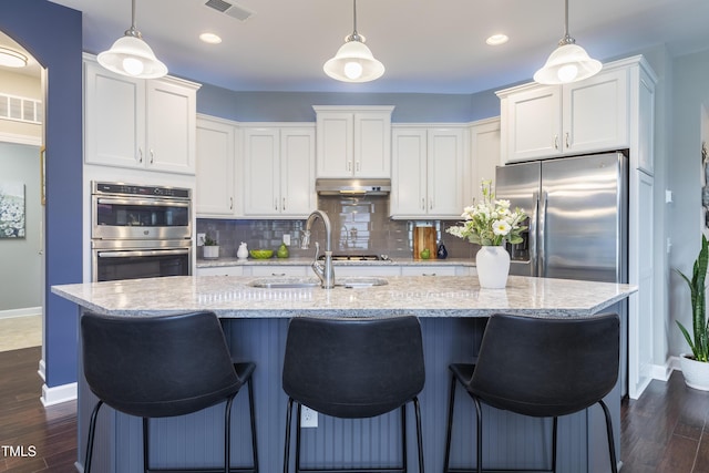 1005 Vesper Ct, Durham, NC 27703 - kitchen featuring stainless steel appliances, baseboards, a sink, backsplash, and white cabinets