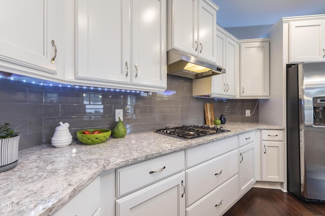 1005 Vesper Ct, Durham, NC 27703 - kitchen featuring stainless steel appliances, under cabinet range hood, white cabinetry, backsplash, and light stone counters