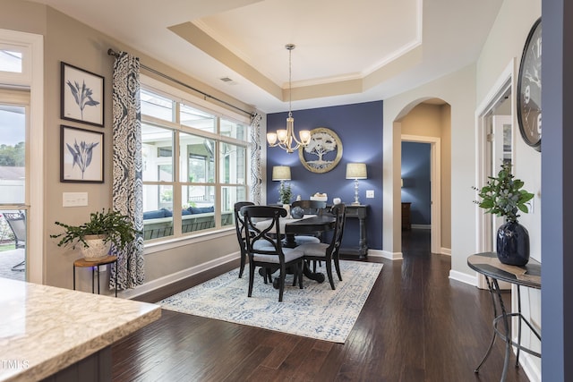1005 Vesper Ct, Durham, NC 27703 - dining space with arched walkways, a raised ceiling, dark wood-style floors, a chandelier, and ornamental molding