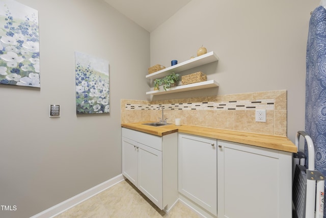 1005 Vesper Ct, Durham, NC 27703 - indoor wet bar with backsplash, baseboards, and lofted ceiling