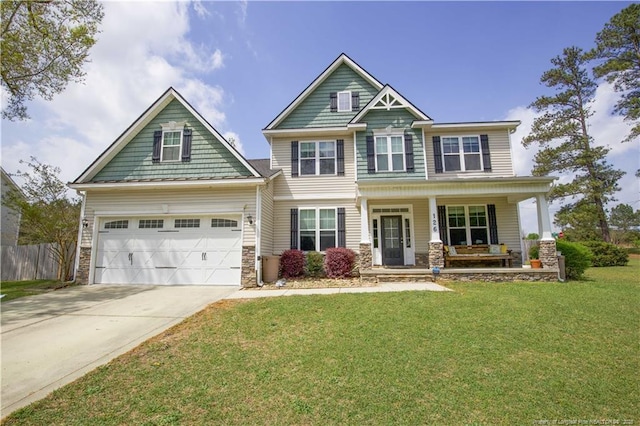 craftsman house with a front yard, stone siding, covered porch, fence, and concrete driveway
