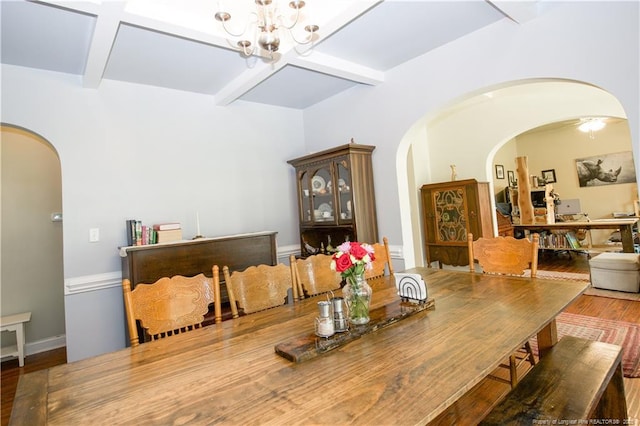 dining area featuring beamed ceiling, arched walkways, a chandelier, and wood finished floors