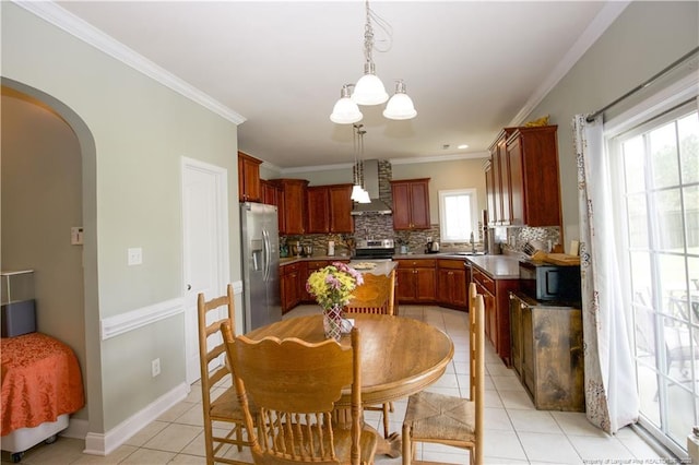 kitchen with wall chimney range hood, tasteful backsplash, a notable chandelier, and appliances with stainless steel finishes