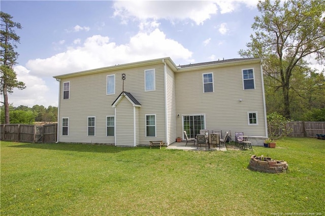 rear view of house with an outdoor fire pit, a patio, a yard, and fence