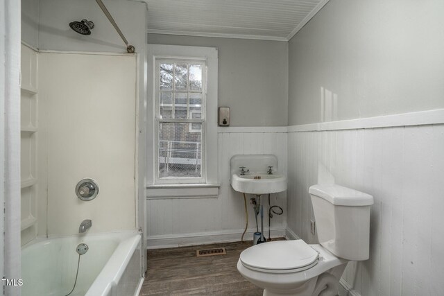 703 Cokey Rd, Rocky Mount, NC 27801 - bathroom featuring visible vents, shower / washtub combination, toilet, wood finished floors, and a wainscoted wall