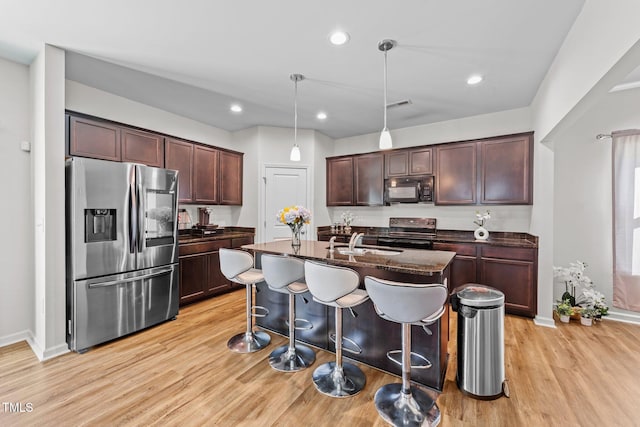 95 Shady Creek Trl, Garner, NC 27529 - kitchen with a sink, stainless steel appliances, light wood-type flooring, a breakfast bar, and baseboards