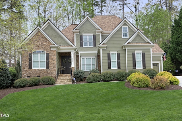 craftsman-style home featuring a front yard, an attached garage, stone siding, and roof with shingles