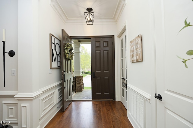 entrance foyer with crown molding, a decorative wall, and dark wood-style floors