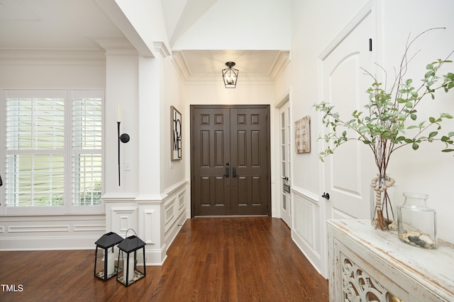 entryway with a decorative wall, ornamental molding, and dark wood finished floors