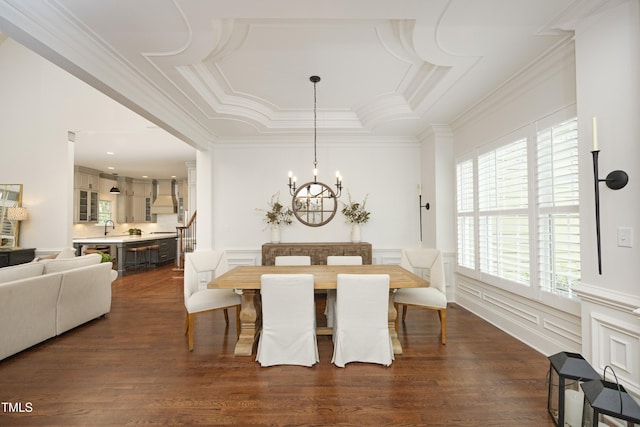 dining space featuring a decorative wall, dark wood finished floors, ornamental molding, a chandelier, and a raised ceiling