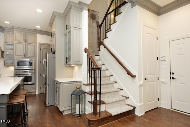 stairway featuring crown molding, wood finished floors, and recessed lighting