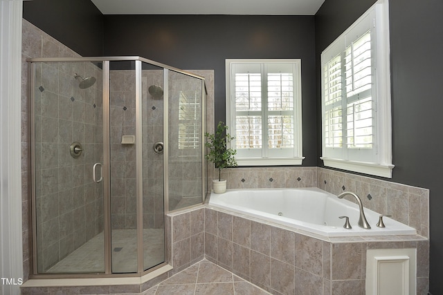 bathroom with a stall shower and a garden tub