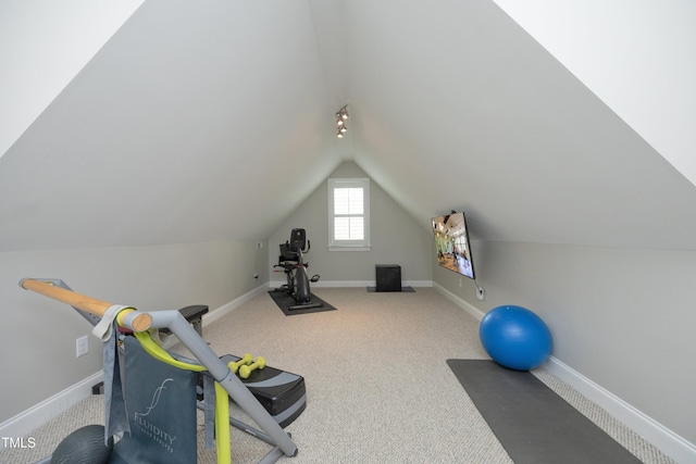 workout room with carpet flooring, baseboards, and vaulted ceiling