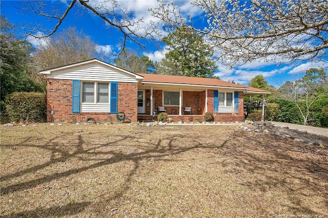 single story home with brick siding, a front lawn, and covered porch