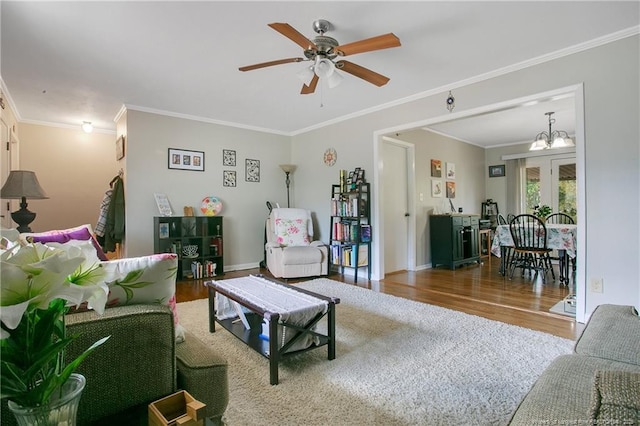 living room featuring ornamental molding, baseboards, a ceiling fan, and wood finished floors
