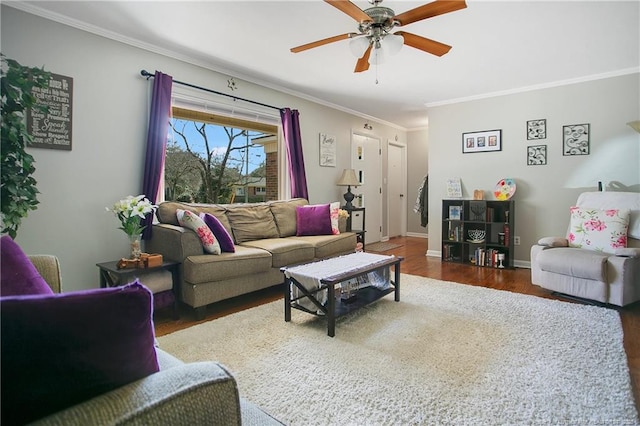 living area featuring crown molding, wood finished floors, baseboards, and a ceiling fan