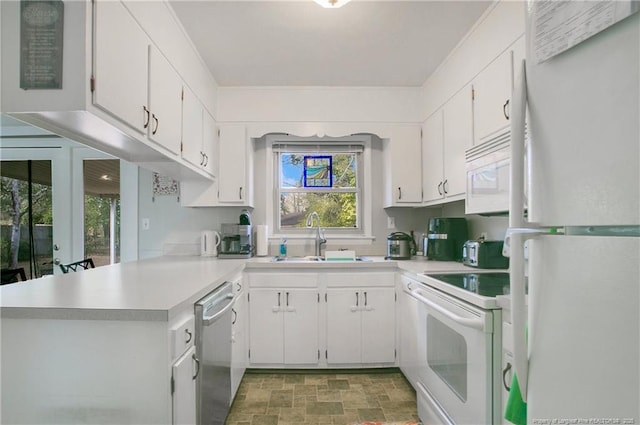 kitchen with stone finish flooring, white appliances, light countertops, and a sink