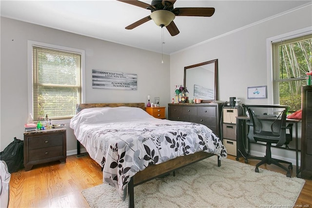 bedroom featuring ornamental molding, baseboards, a ceiling fan, and wood finished floors
