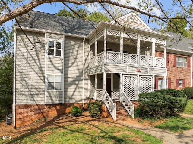 neoclassical / greek revival house featuring stairway and a shingled roof