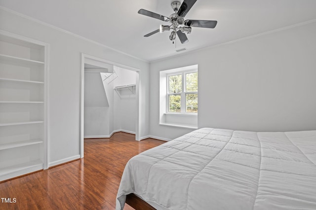 bedroom featuring a closet, baseboards, crown molding, and wood finished floors
