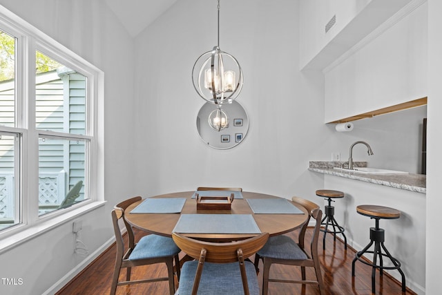 dining room with baseboards, an inviting chandelier, lofted ceiling, and dark wood finished floors