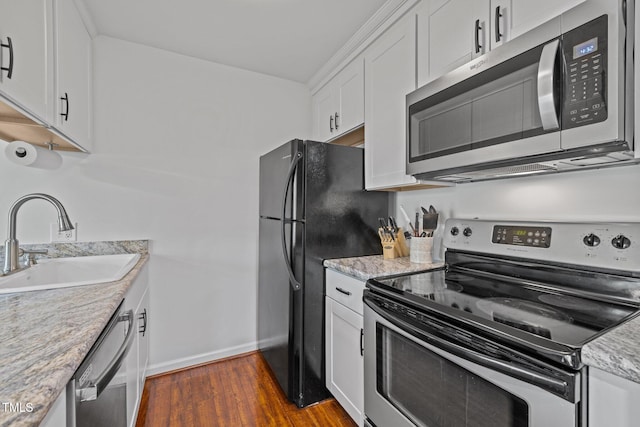 kitchen with baseboards, a sink, white cabinetry, stainless steel appliances, and dark wood-type flooring