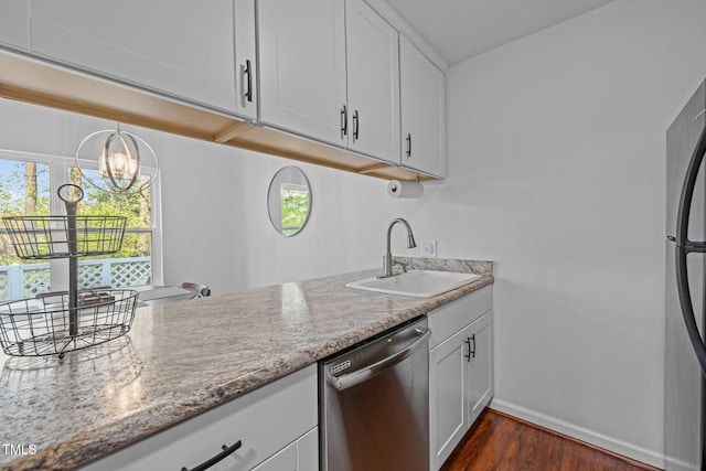 kitchen with white cabinets, baseboards, a sink, stainless steel appliances, and dark wood-type flooring