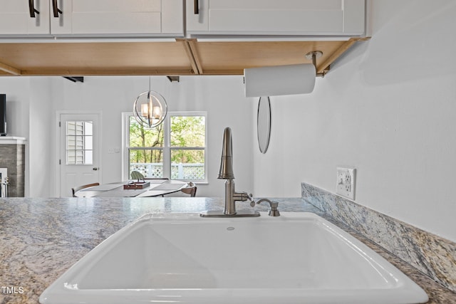 interior space with a sink, white cabinetry, and an inviting chandelier