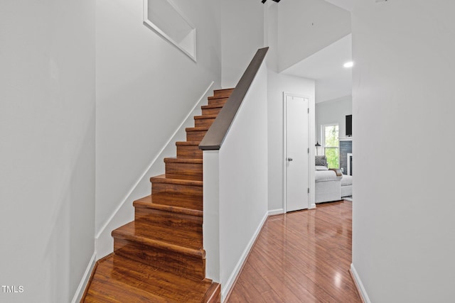 staircase featuring baseboards and wood finished floors